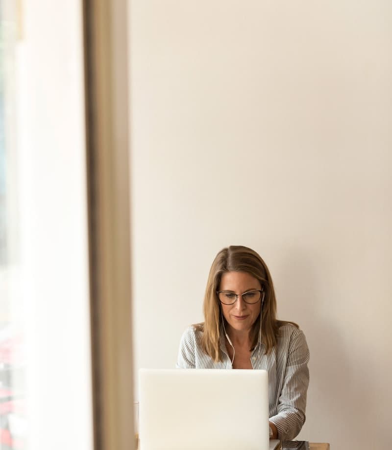 Woman working over coffee at a café table